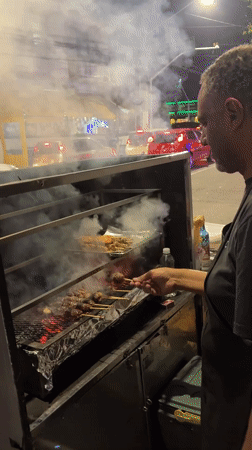 São Paulo side street buzzing with murals, food stalls, and night commerce
