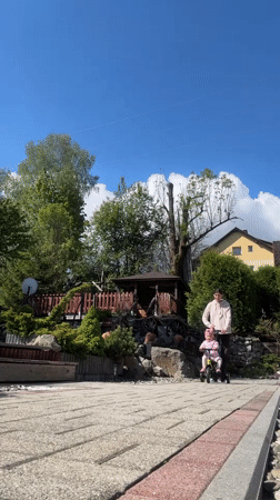 Child rides tricycle on sunny morning in Wisła, Poland