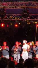Brass band and vocalist perform at outdoor night concert in Ugarchin