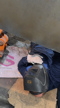 Welder performs floor-level work at Pleven industrial facility