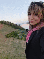 Woman films sunset selfie on hill in Ольховка, Russia
