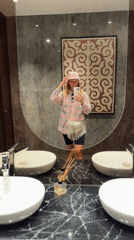 Woman takes mirror selfie in modern Almaty bathroom