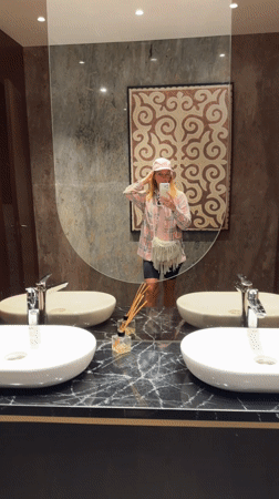 Woman takes mirror selfie in modern Almaty bathroom