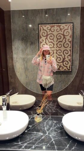 Woman takes mirror selfie in modern Almaty bathroom