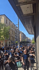 Large crowd in dark clothing marches through Sofia streets
