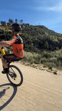 Cyclist rides mountain bike on dirt trail in Portugal