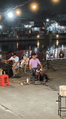 Waterfront band plays under string lights in Surakarta at night