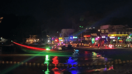 Nighttime beach yoga session captured in Thai tourist district