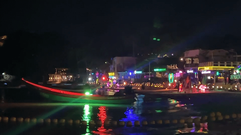 Nighttime beach yoga session captured in Thai tourist district