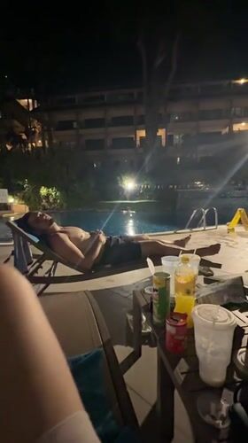 Man relaxes poolside at Karon resort during evening hours