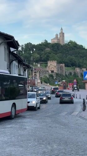 Tourist documents historic Veliko Tarnovo during evening hillside tour