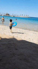 Boy walks across sunny beach in Hurghada, Egypt