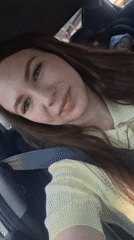 Woman in yellow shirt sits calmly in car, Chaikovsky