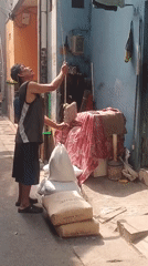 Goods being weighed by rope in a West Jakarta alleyway