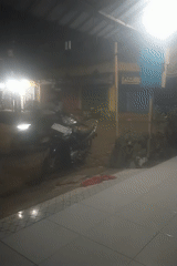 Night gathering around motorcycles on wet Lumajang streets