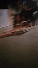 Young adults ride horses through nighttime streets in Cabo Frio