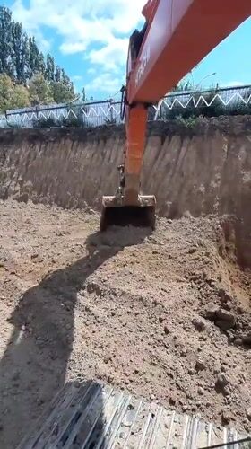 Excavator digs and clears earth at Pivdennoukrainsk construction site