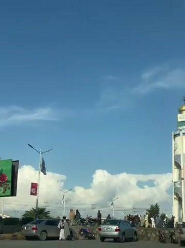 Normal traffic flows past clock tower in Kandahar