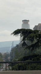 Overcast cityscape captured from Tbilisi bridge showing distinctive tower