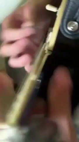 Here is a concise description of the video:

The video shows a close-up view of a person's hands playing an electric guitar. The guitar is black with a white binding and silver frets. The person is wearing a strap on the guitar. The camera focuses on the person's fingers as they move along the frets. The background is blurred. The person plays the guitar fast and with some complexity.