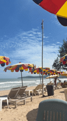 Colorful beach umbrellas shade lounge chairs in Choeng Thale