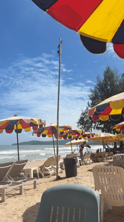 Colorful beach umbrellas shade lounge chairs in Choeng Thale