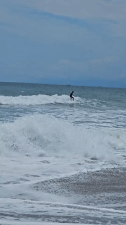 Early morning surfer rides choppy waves in Kamakura