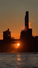Sun sets between smokestacks at a New York power plant