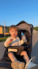 Toddler in stroller on residential street during golden hour