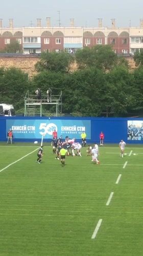 Rugby match underway in Krasnoyarsk with team banner on display