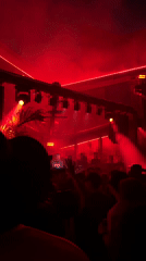 Late-night NYC event, red lights inside and a smoky outdoor stage