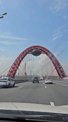 Morning traffic crosses red-arched bridge in Moscow