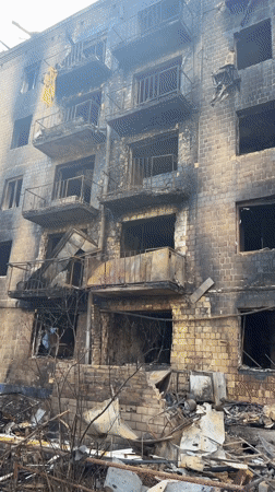Fire-gutted Kyiv apartment building, teddy bear left on railing