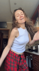 Woman dances in kitchen during morning routine in Ukraine