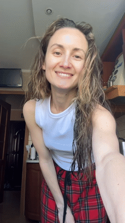 Woman dances in kitchen during morning routine in Ukraine