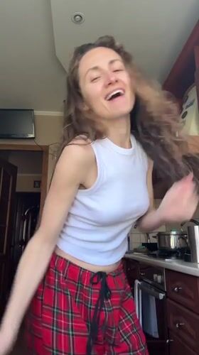 Woman dances in kitchen during morning routine in Ukraine