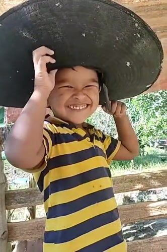 Playful hat moment under a wooden structure in Aceh