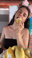 Woman in bear headband eats durian in Mũi Né