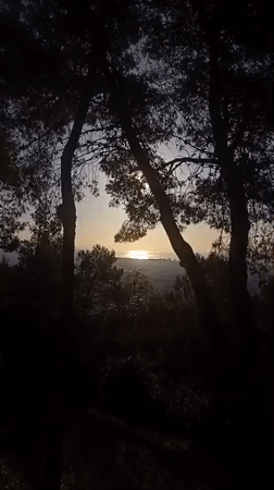 Morning Barcelona cityscape viewed from hillside with cat keychain