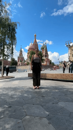 Tourist dances at Red Square as street musicians perform nearby