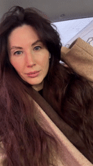 Woman in car gestures and smiles in Perm