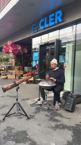 Street musician performs with handpan outside Lausanne bank