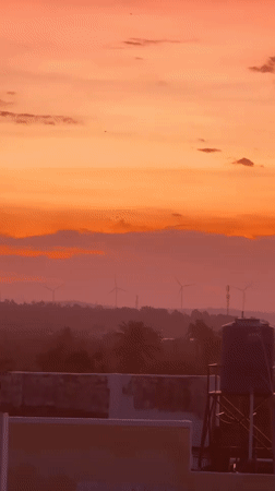 Mũi Né sunset fades from orange to purple over wind turbines