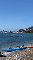 Kayaking group launches from Budva beach on sunny morning