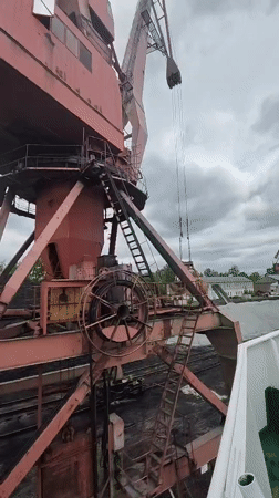 Cargo cranes operate at Medvezhyegorsk port facility under overcast skies