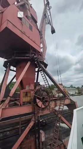 Cargo cranes operate at Medvezhyegorsk port facility under overcast skies