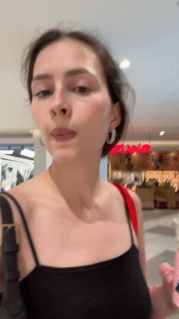 Woman walks through Al Ain mall carrying drink