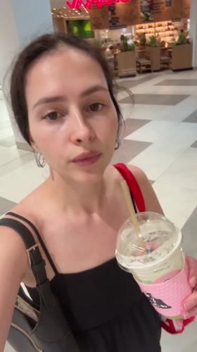 Woman walks through Al Ain mall carrying drink