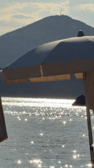 Beach umbrella shields afternoon sun as water shimmers
