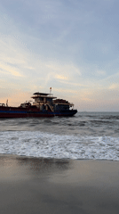 Large fishing vessel beached on Đà Nẵng shore at twilight